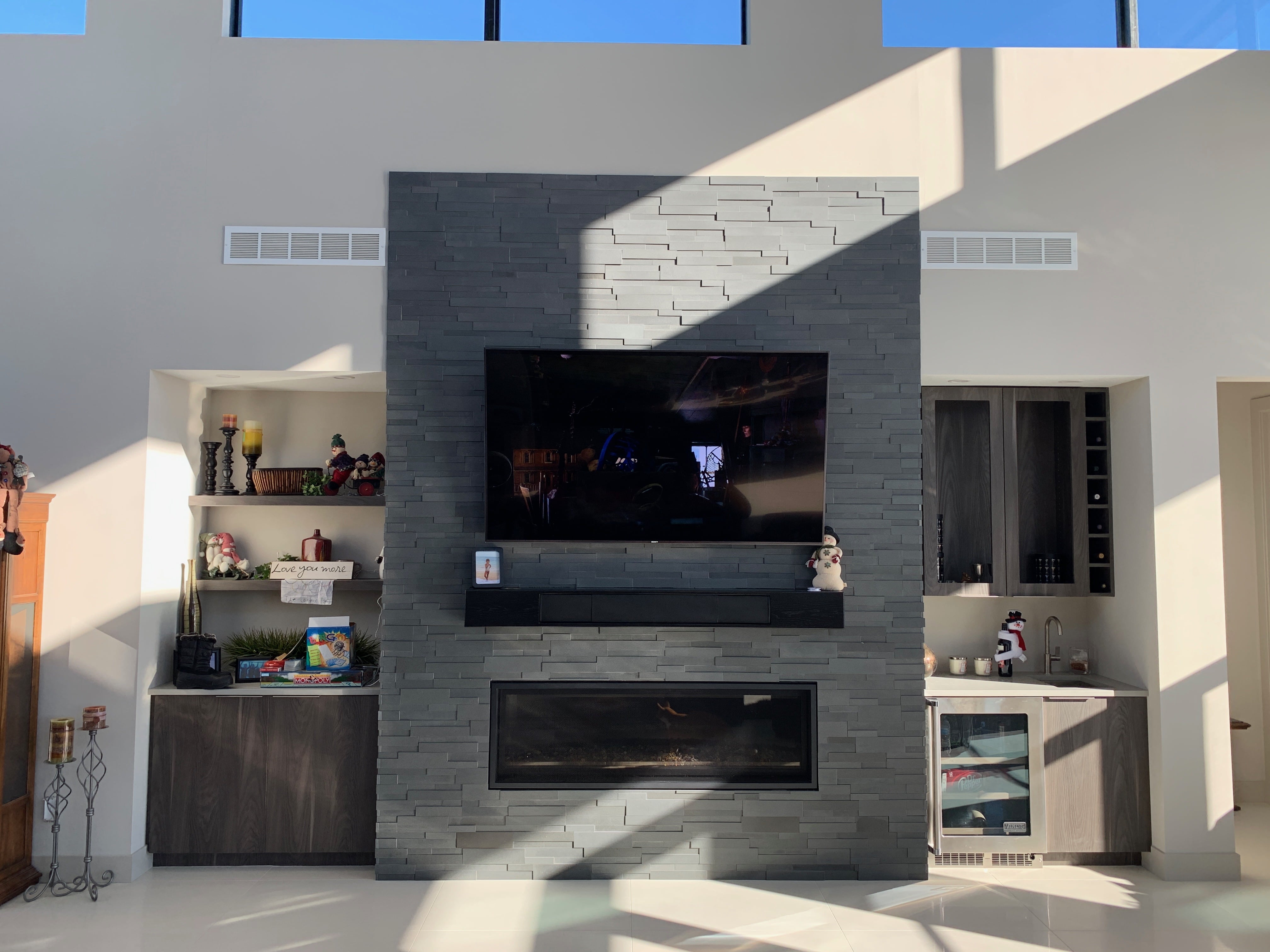 Norstone Aksent 3D Stone Panels in Ash Grey used on a modern fireplace with a large tv mounted above a linear gas insert